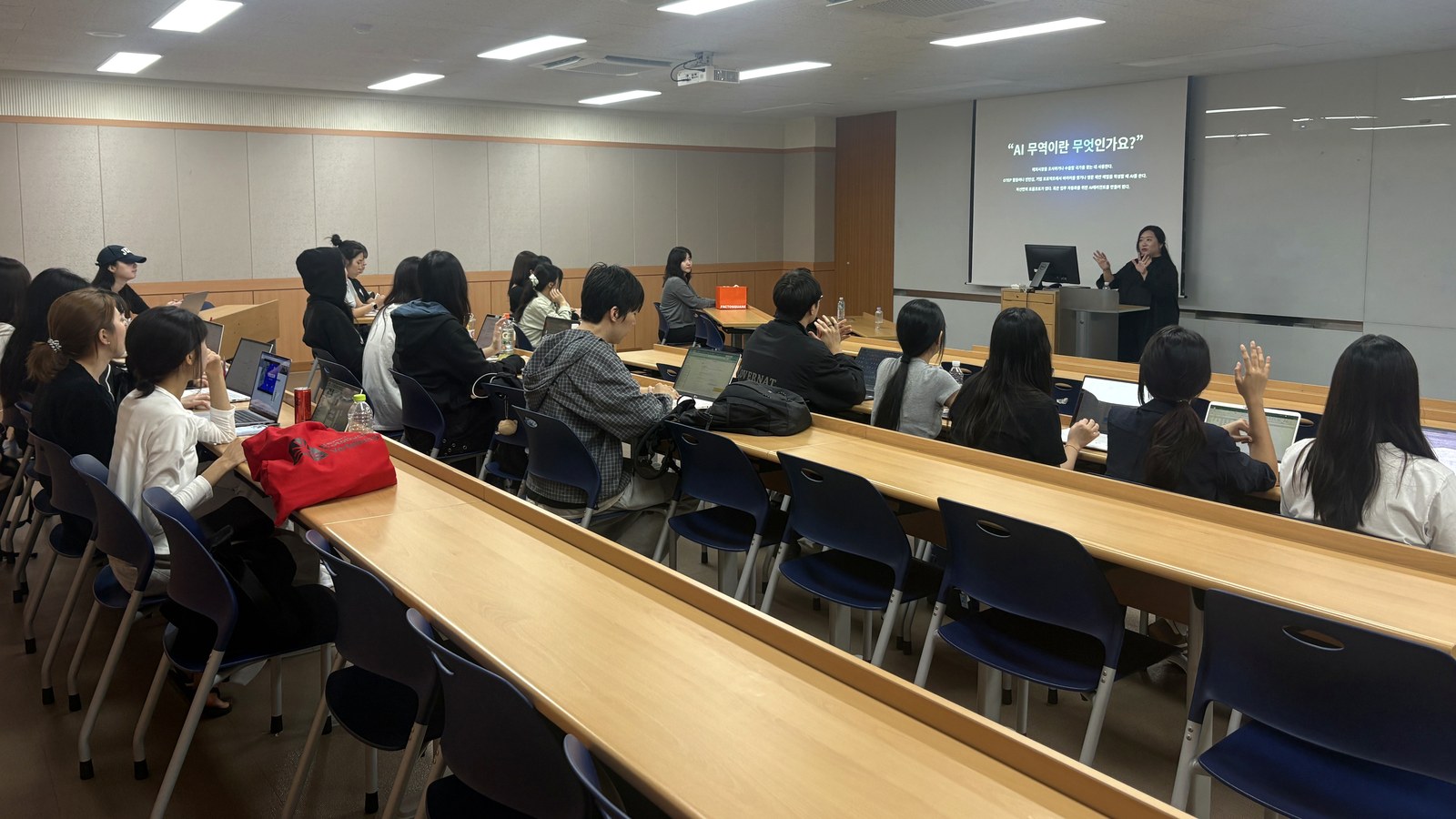 Some students raise their hands as the speaker explains during the Kyung Hee GTEP lecture